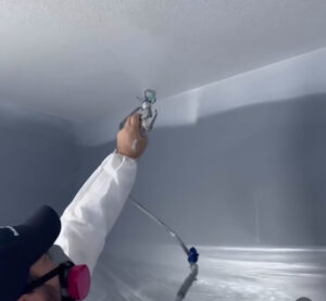 A professional painter wearing protective gear knows when to use a paint sprayer for the best results.